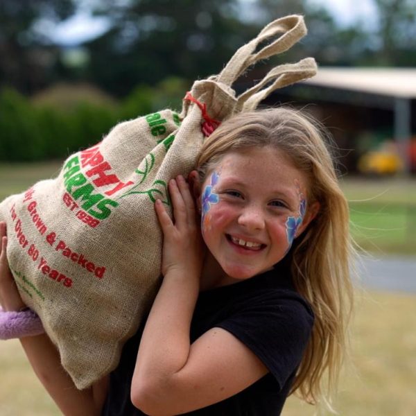 Young girl carrying a bag of potatoes at the Thorpdale Potato Festival